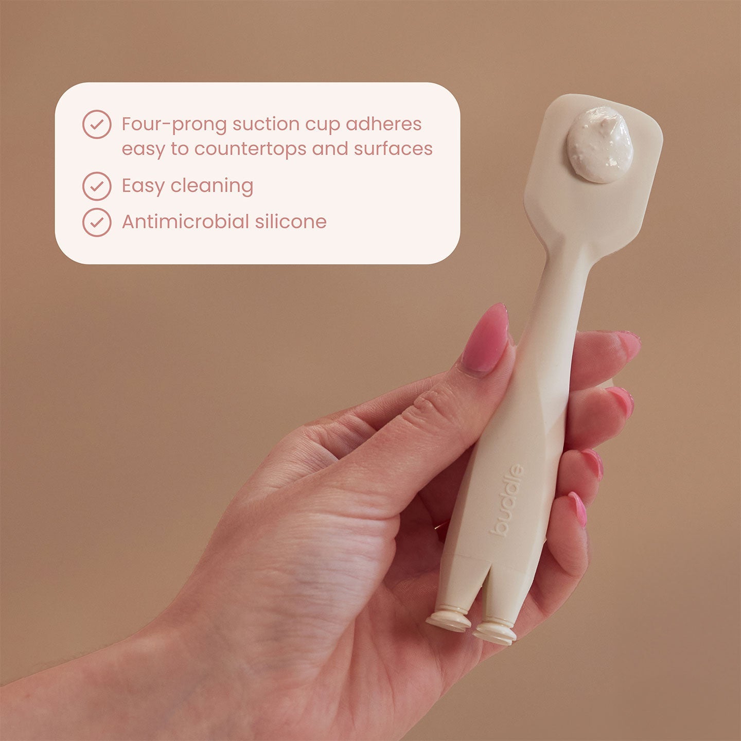 White silicone paddle applicator held in hand, with two suction feet