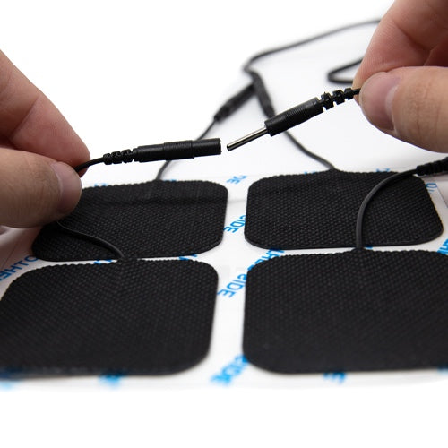 Electrode pad set with attached cable connectors, held during setup