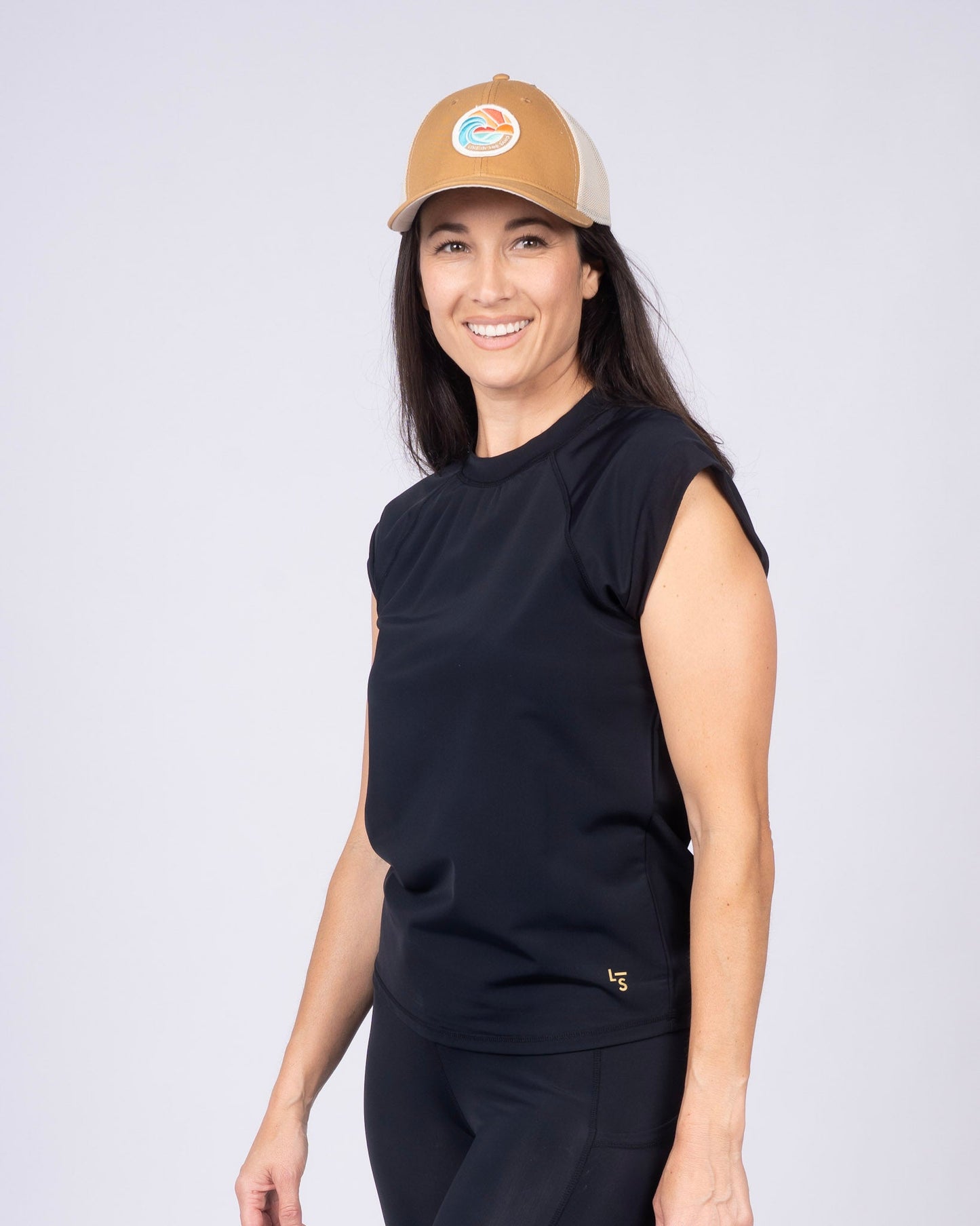 Tan retro patch baseball cap with front circular emblem and mesh side panels