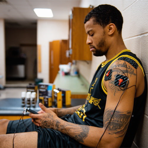 Electrode pads on arm and shoulder connected by wires on a sports jersey wearer
