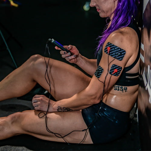 EMS and TENS muscle stimulator electrode pads on upper body with controller and wires