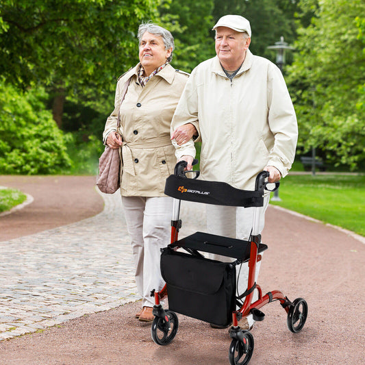 Two elderly people walking together with a rollator in a park.
