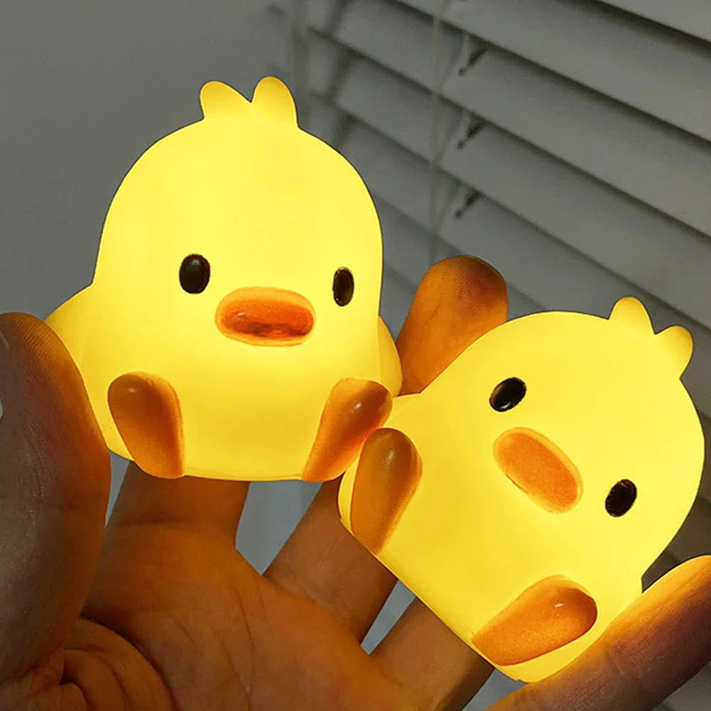Duck-shaped night lights in hands, yellow glowing figures with orange beaks