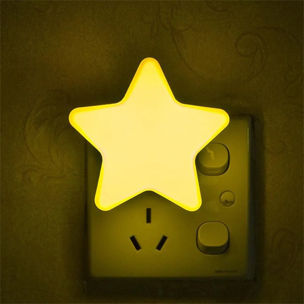 Yellow star LED plug-in night light glowing from a wall outlet.