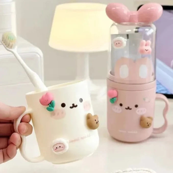 Cute toothbrush holder with clear lid, pink body and bunny face; cream cup beside it