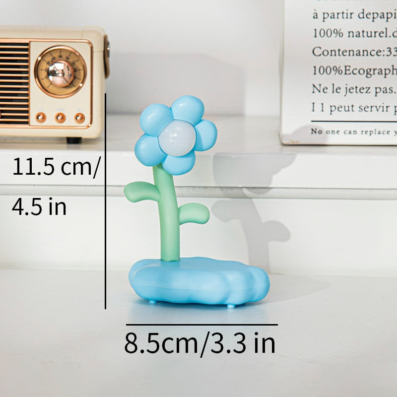 Blue and white flower-shaped night light with green stem and base
