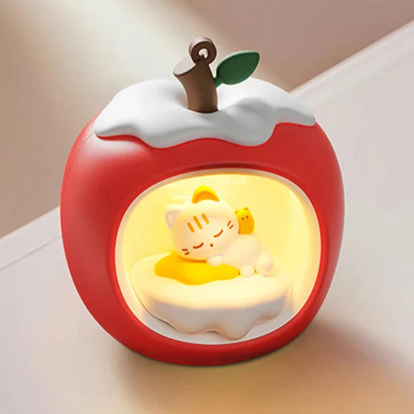 Red apple-shaped night light with sleeping cat figure inside glowing circular window