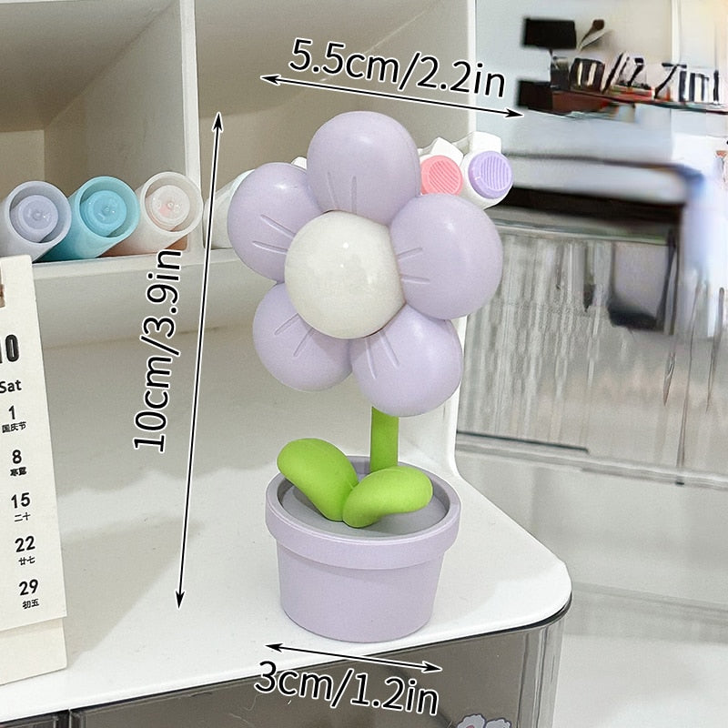 Purple flower night light with glowing center and green leaves in a lilac pot