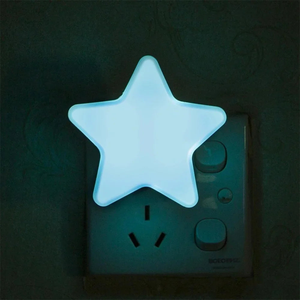 Light blue star LED plug-in night light glowing on a wall outlet.