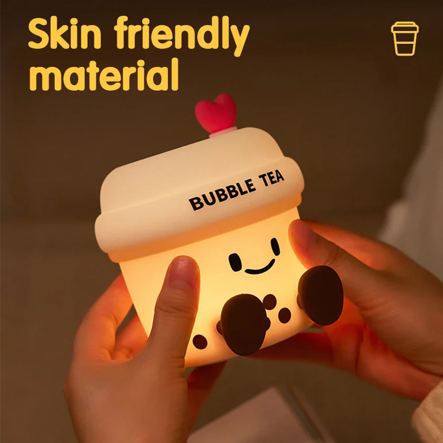 Kawaii bubble tea cup night light glowing, held by hands, with heart lid and dark toppings.