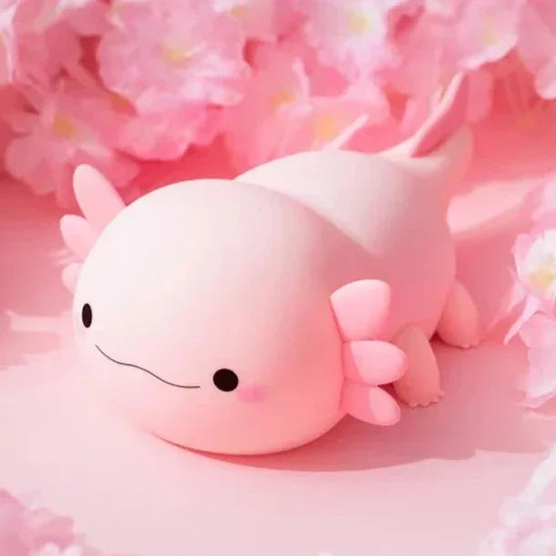 Cream axolotl night light with pink fins, curled pose, soft warm glow