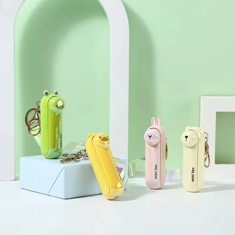 Animal-shaped handheld fan keychains in mint green, yellow, white, and pale pink