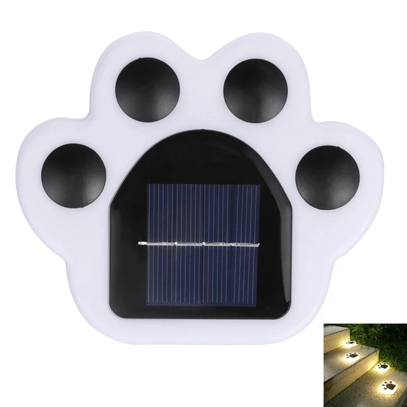 Front view of white paw-shaped solar light with black solar panel and glowing effect