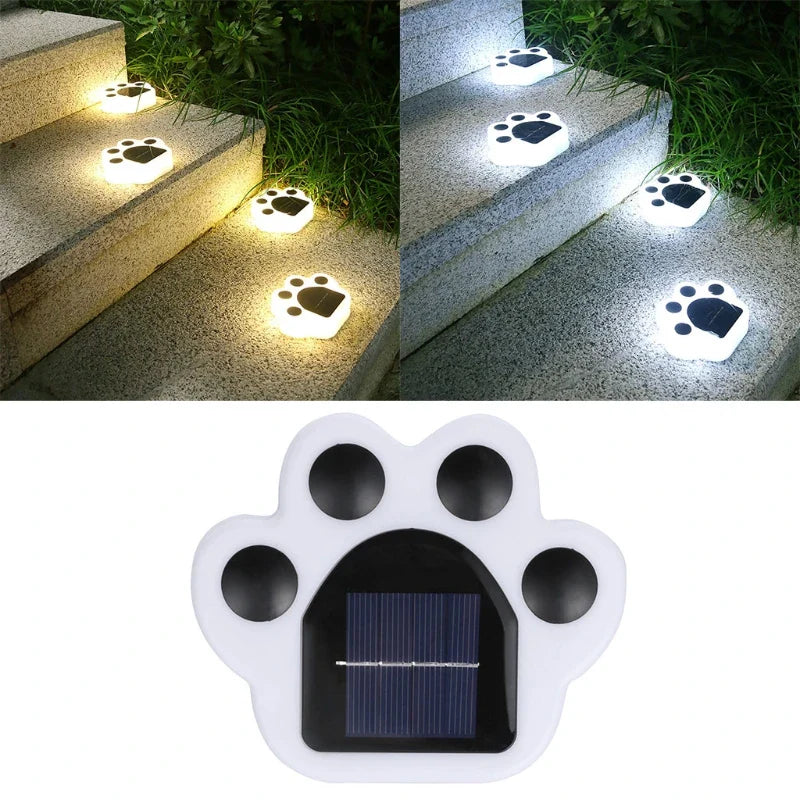 White paw-shaped solar light on stairs with built-in glowing paw icon