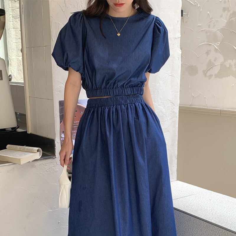 Women’s blue denim puff-sleeve crop top with elastic waist and long gathered skirt