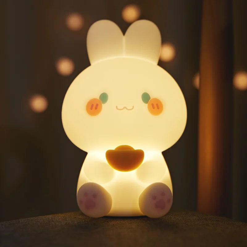 Front view of a white bunny night light with warm glow and yellow heart