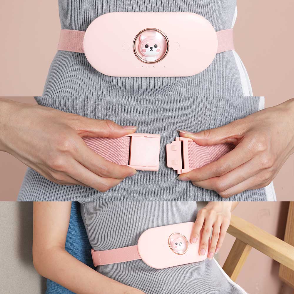 Pink electric heating belt worn on waist over gray fabric with fastened side clip