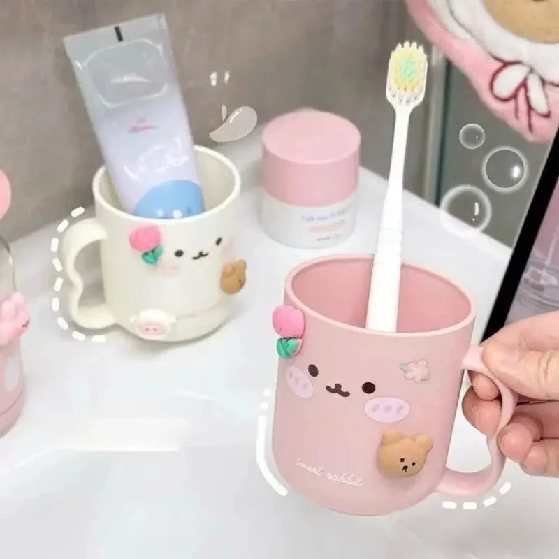 Pink toothbrush cup with animal face print and handle; holds a toothbrush with bristles