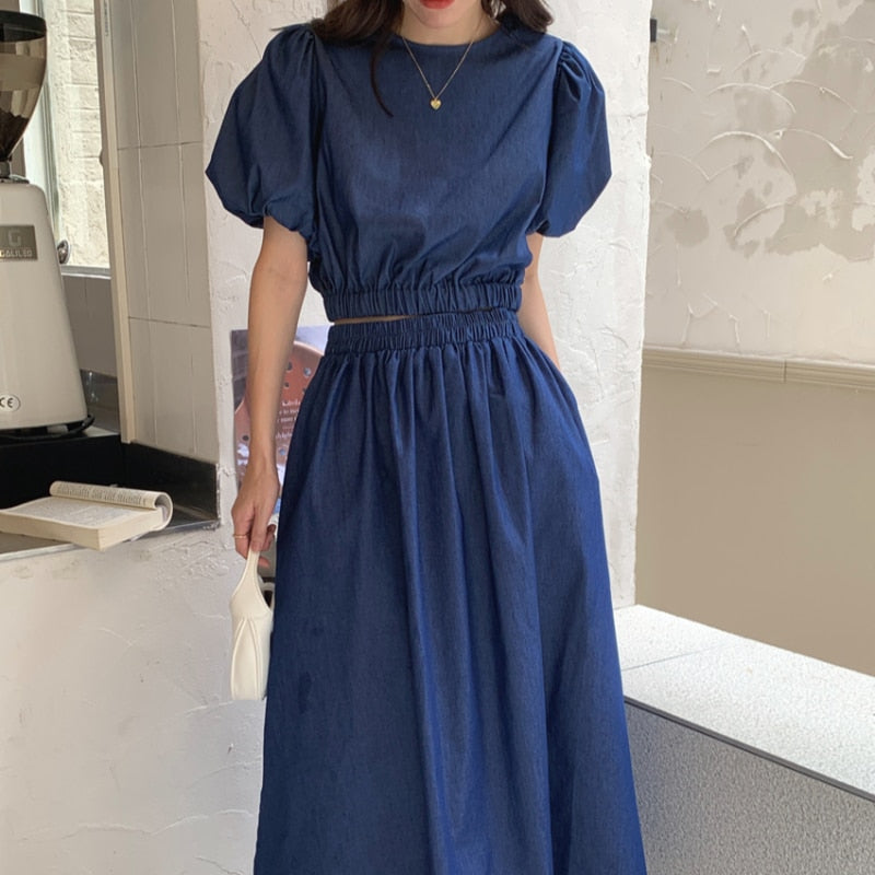 Women’s dark blue denim puff-sleeve crop top with elastic waist and long gathered skirt