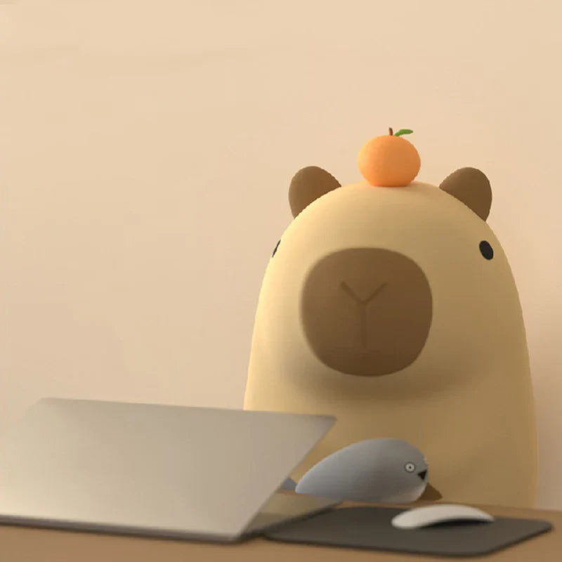 Capybara night light on a shelf with a laptop and mouse nearby