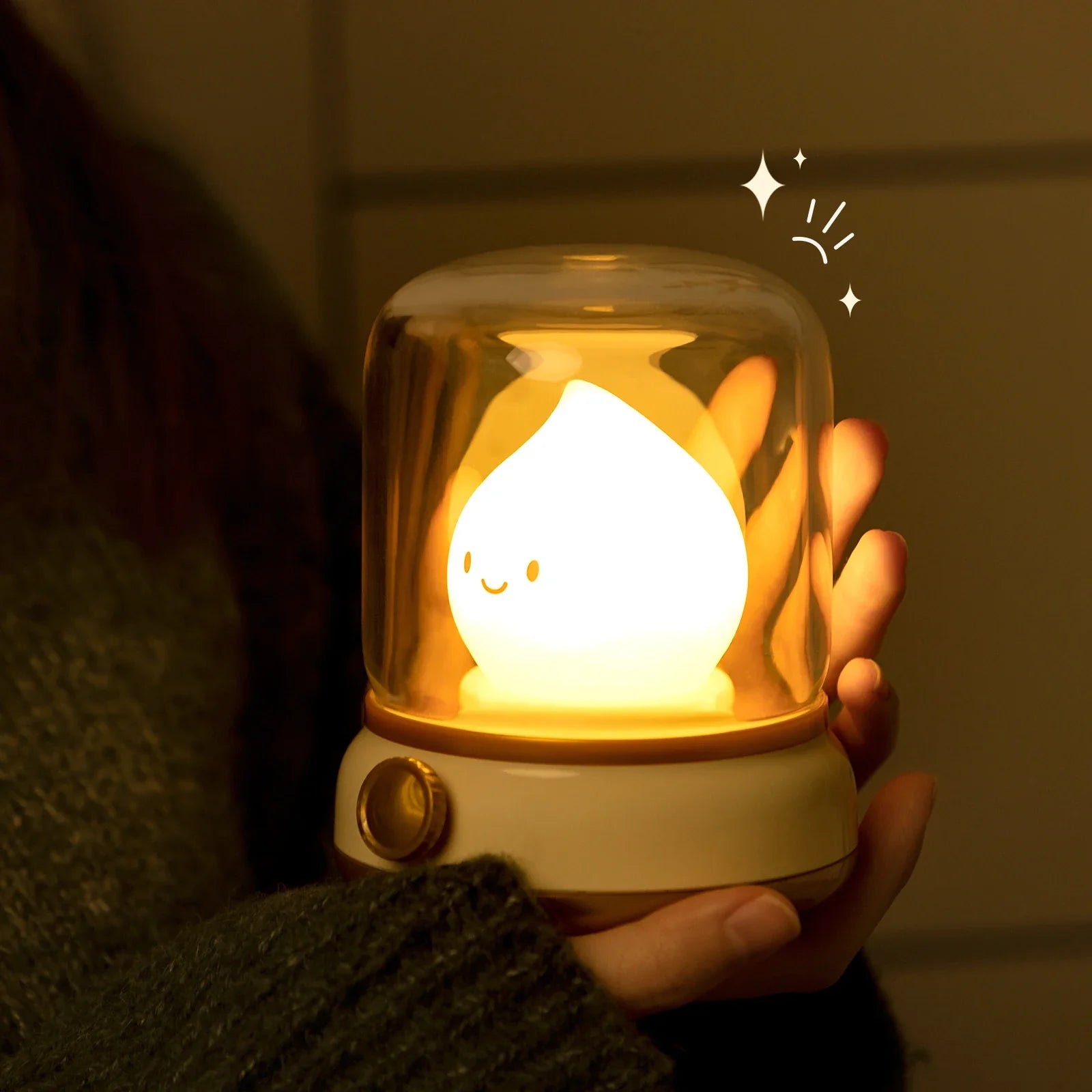Green flame lantern night light held in hand, clear dome with warm glowing flame.