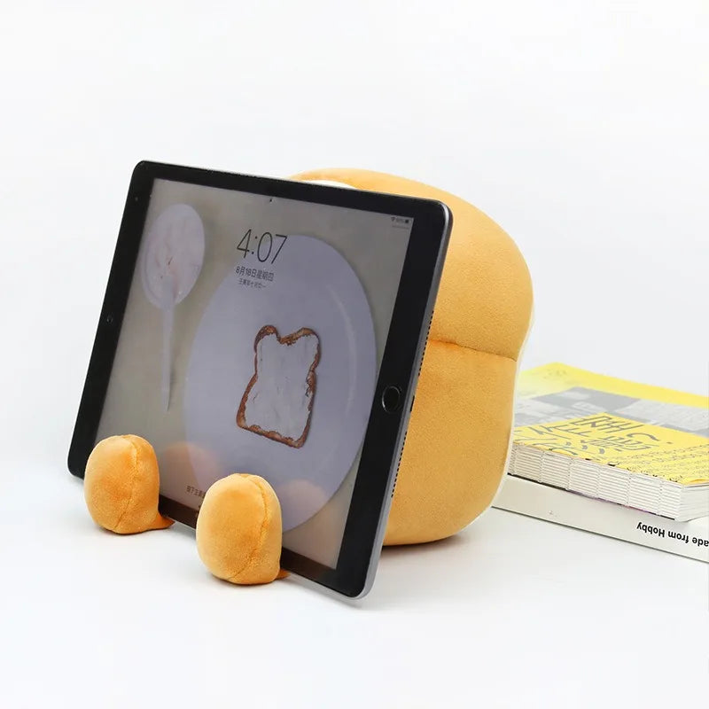 Toast plush alarm clock night light propped beside tablet with digital time