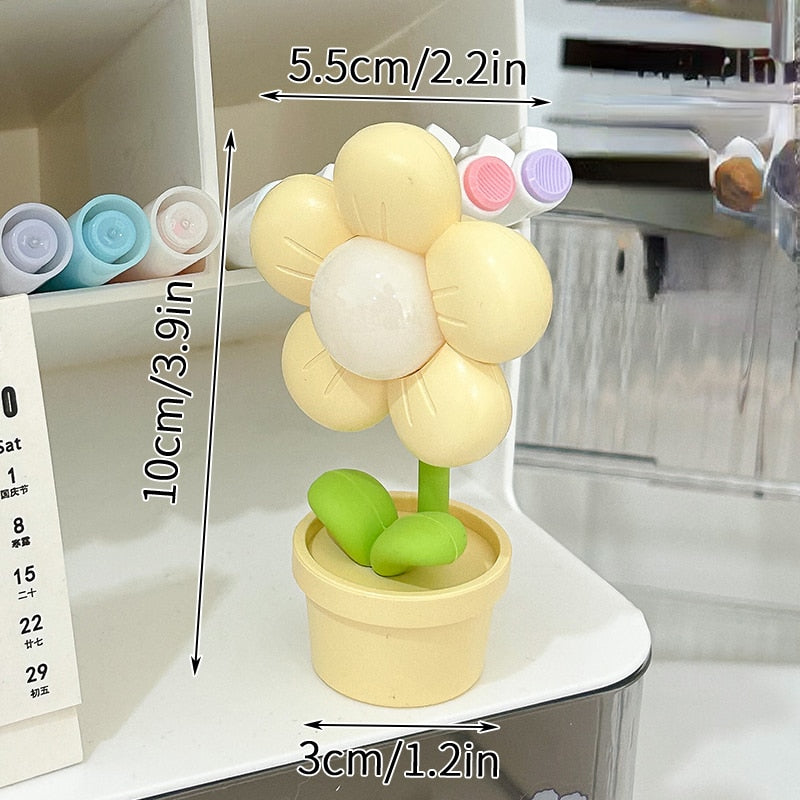 Yellow flower night light with glowing center and green leaves in a beige pot