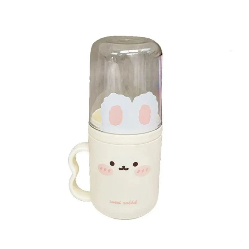 Cream toothbrush holder with clear lid and handle; bunny face graphic on the front