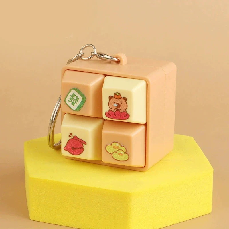 Light tan animal fidget clicker keychain cube with bear, duck, and cloud icons.