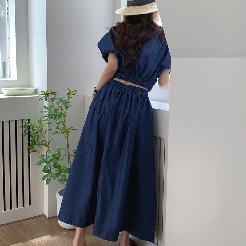Women’s dark blue denim puff-sleeve crop top with elastic waist and gathered midi skirt, back