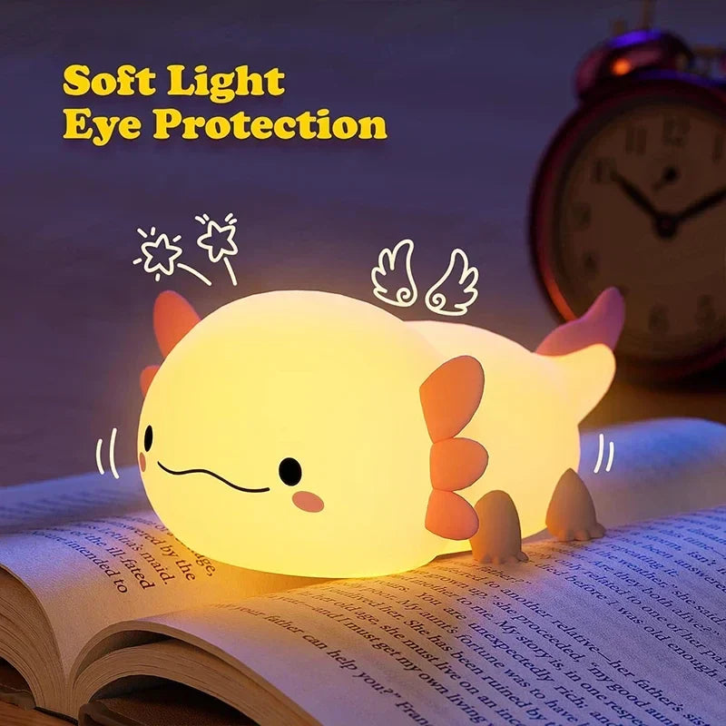 Glowing cream axolotl night light with pink fins, on a book, cute smiling face