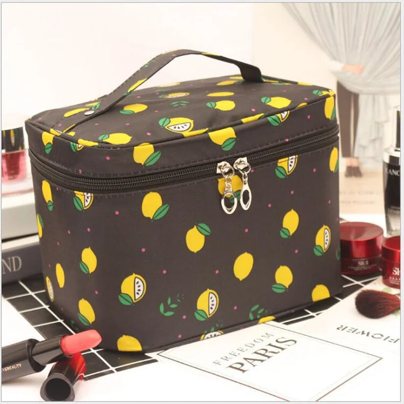 Black cosmetics toiletry bag with lemon leaf print, top handle and zip closure