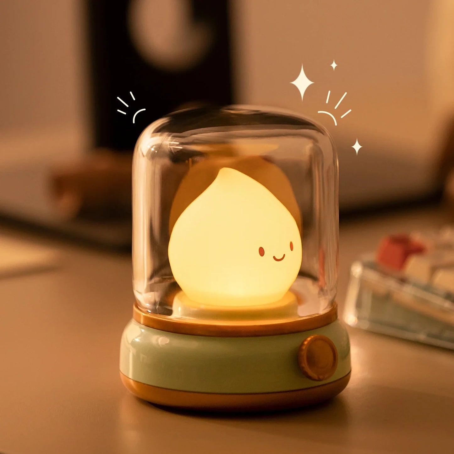 Green flame lantern night light on tabletop with clear dome and glowing smiling flame.