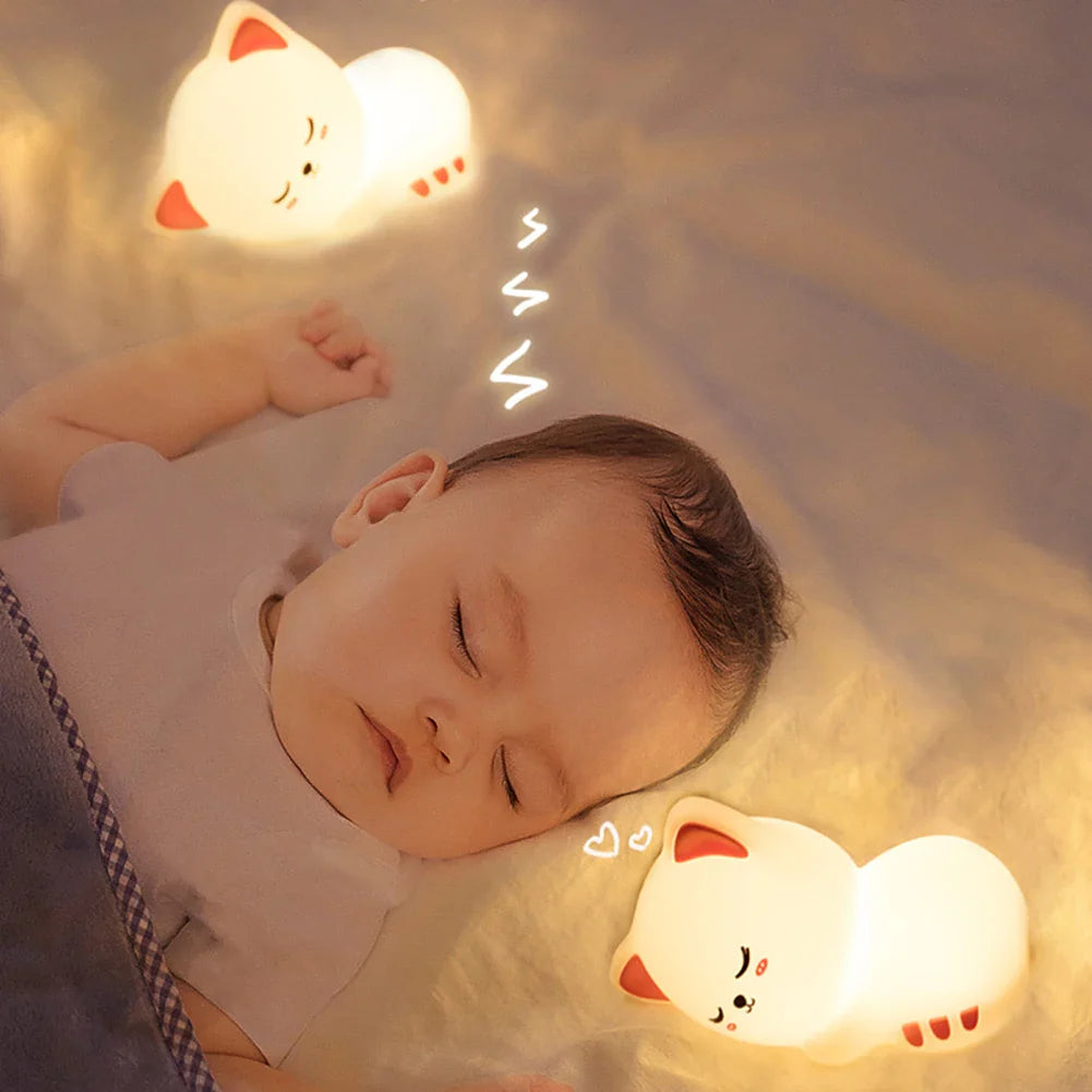 Sleepy kitty night light glowing next to a sleeping child on a bed