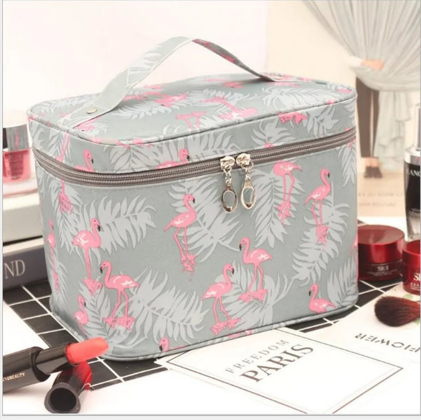 Grey cosmetics toiletry bag with pink flamingo print, top handle and zip closure