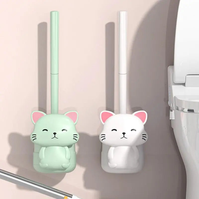 Mint and white cat-shaped wall toilet brushes with tall vertical handles.