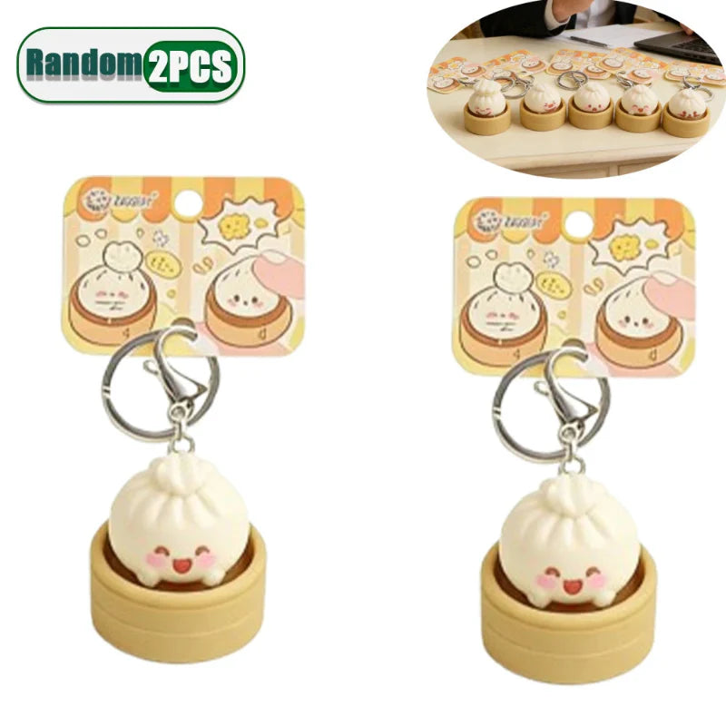 Two dumpling fidget clicker keychains, tan mini containers with cute faces, metal rings