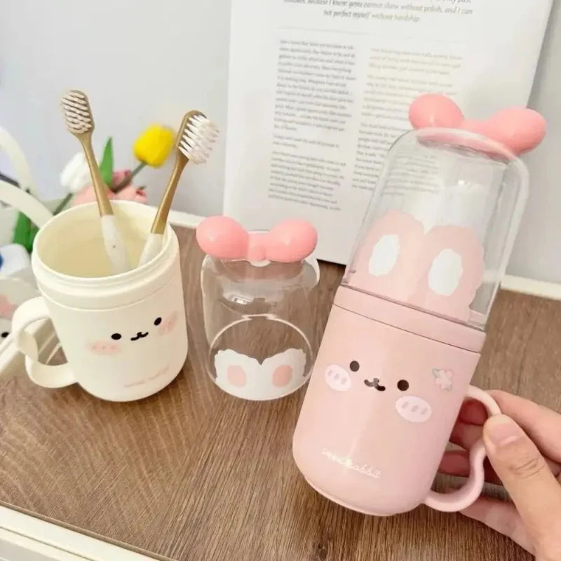 Cute toothbrush holders with animal graphics and handles: pink and cream cups with toothbrushes