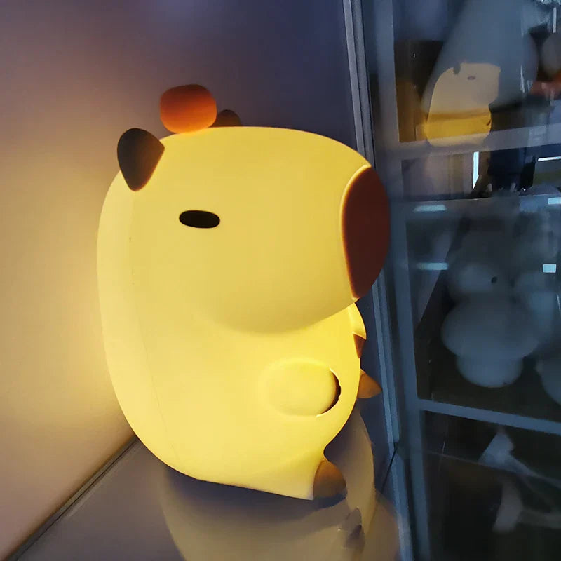 Capybara night light glowing yellow in a dark hallway, side profile view