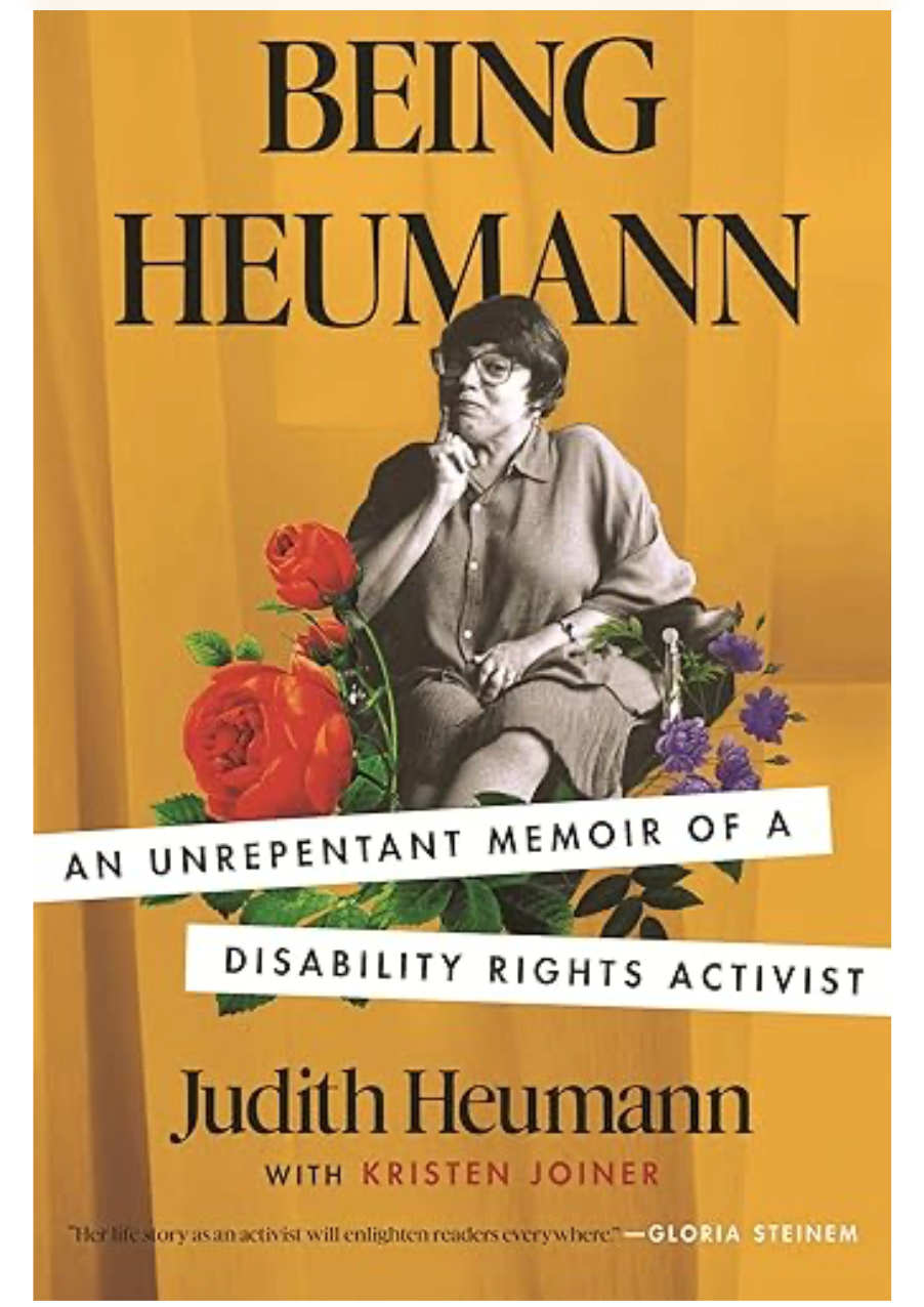 Book cover of Being Heumann by Judy Heumann showing Judy in her wheelchair surrounded by flowers on a yellow background