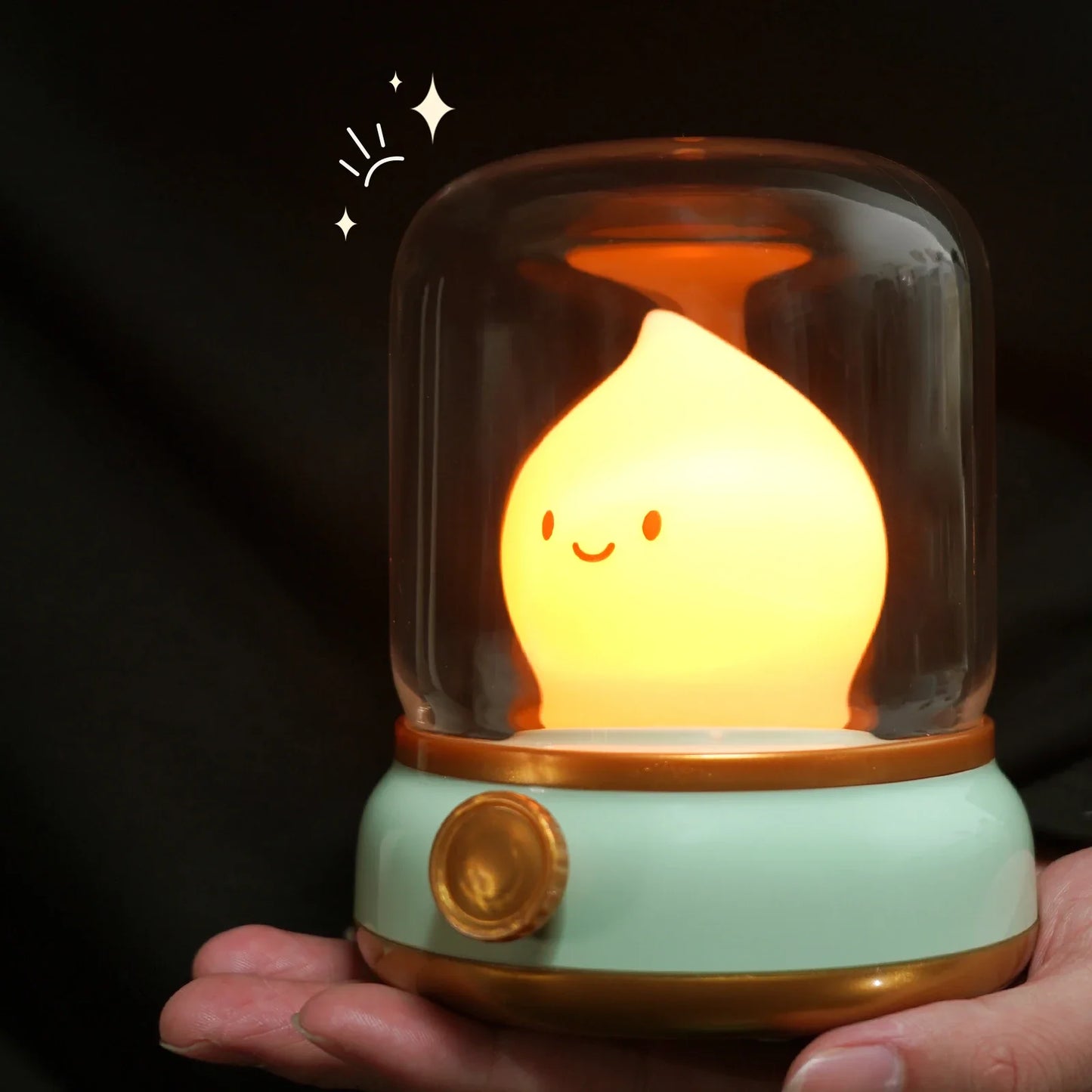 Green flame lantern night light close-up with clear dome and warm glowing flame character.