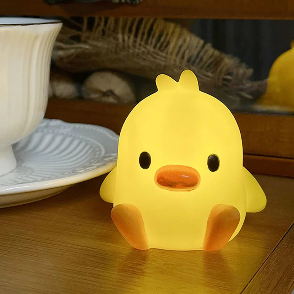 Single yellow duck-shaped night light with orange beak and black eyes on floor