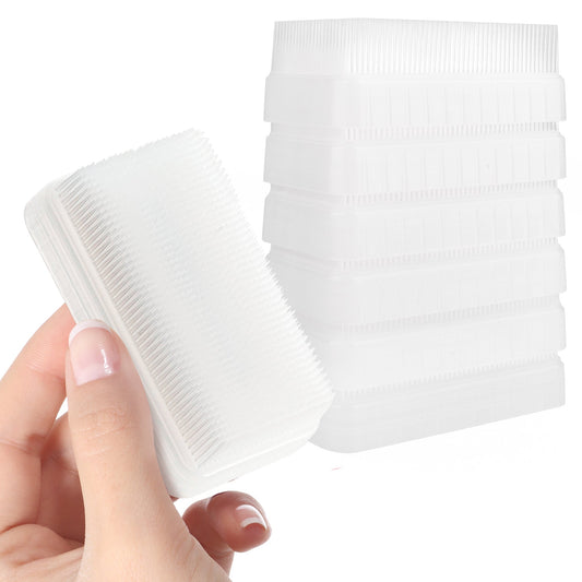 White sensory therapy brush with dense bristles and ridged handle end; handheld design