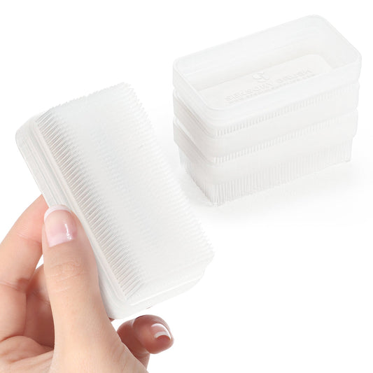 Sensory therapy brush with white handle and soft bristles, held in hand.