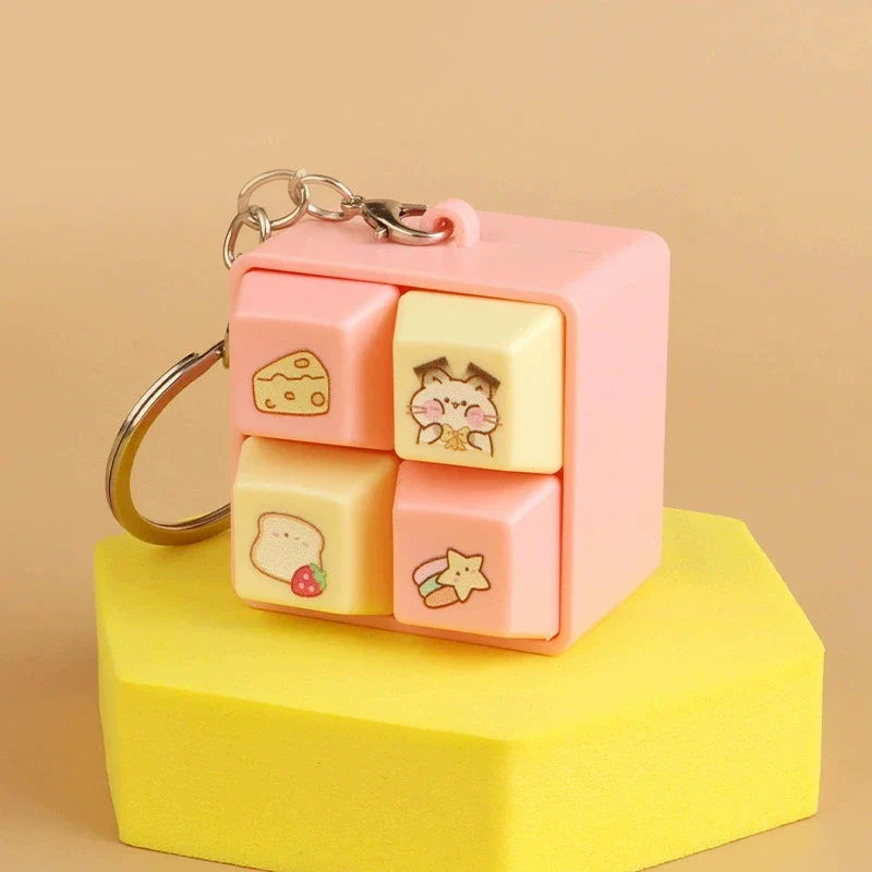 Pink animal fidget clicker keychain cube with cat, star, and mushroom icons.