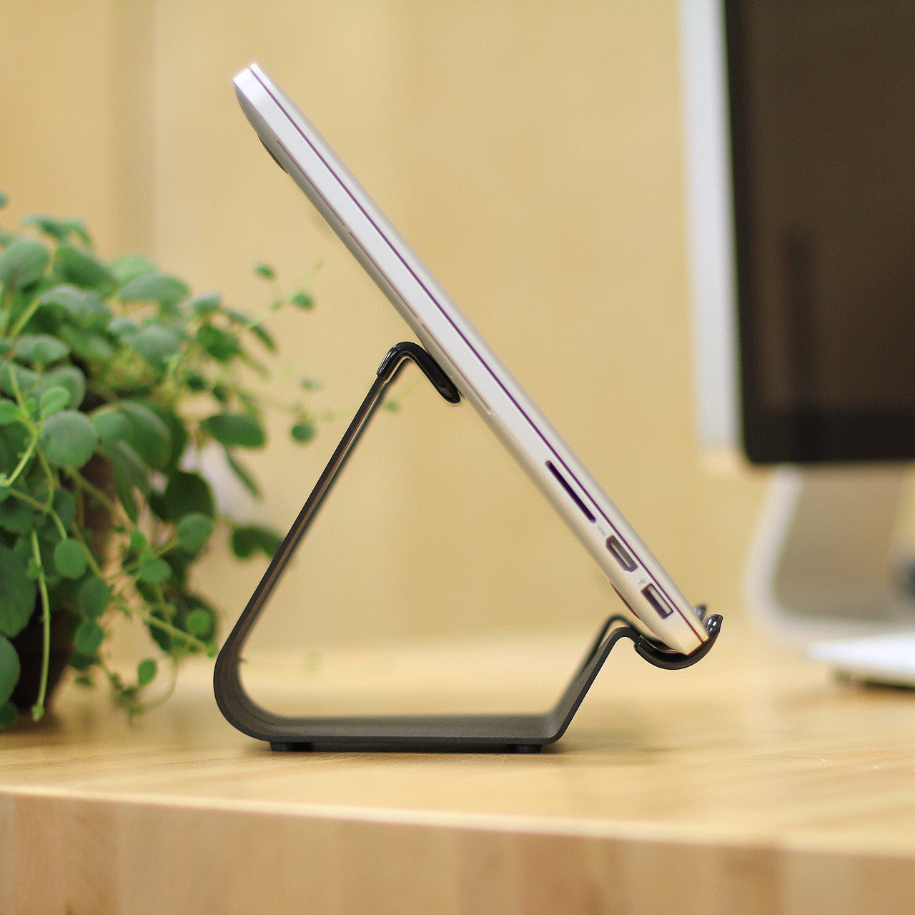 Compact fixed-angle iPad stand in silver with stable triangular base