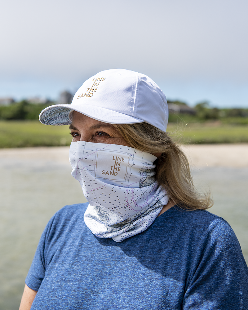 Solar gaiter with white nautical chart print and LINE THE SAND, worn outdoors
