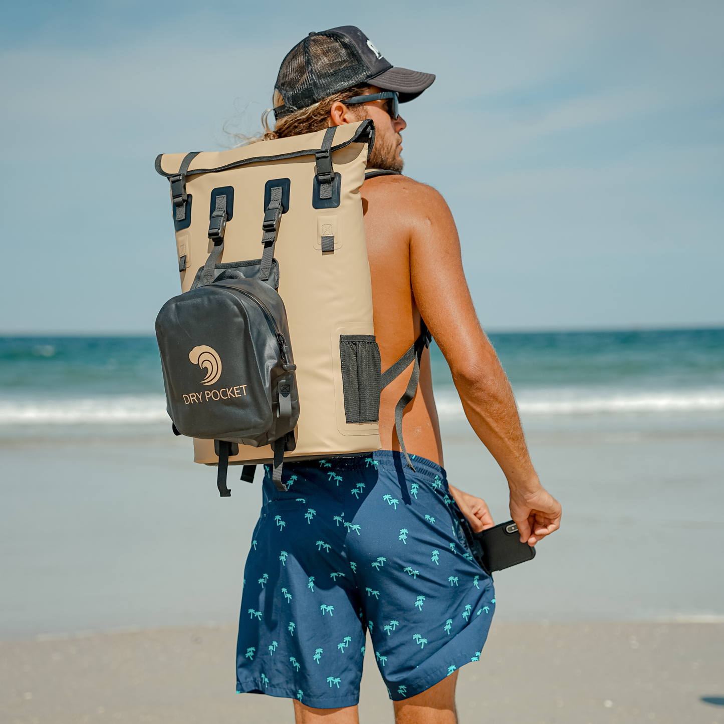 Waterproof floating backpack cooler worn on back, beige with black straps and DRY POCKET pouch