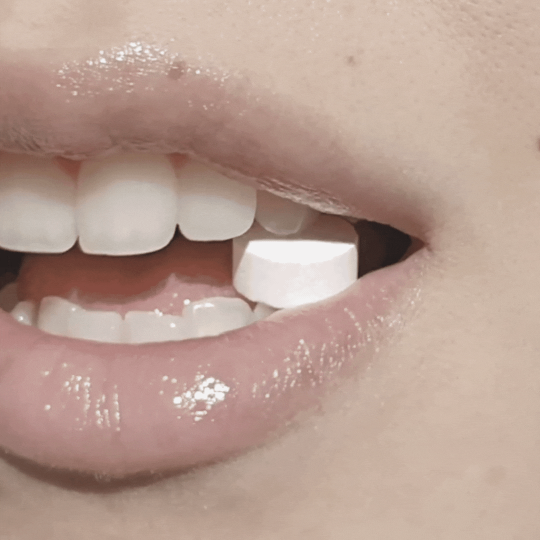 Toothpaste tablet dissolving in mouth with visible gentle foam