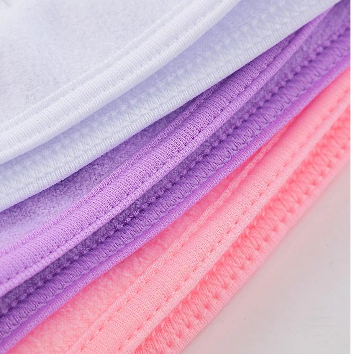 Adjustable spa headband fabric strips in purple, pink, and white, ribbed texture